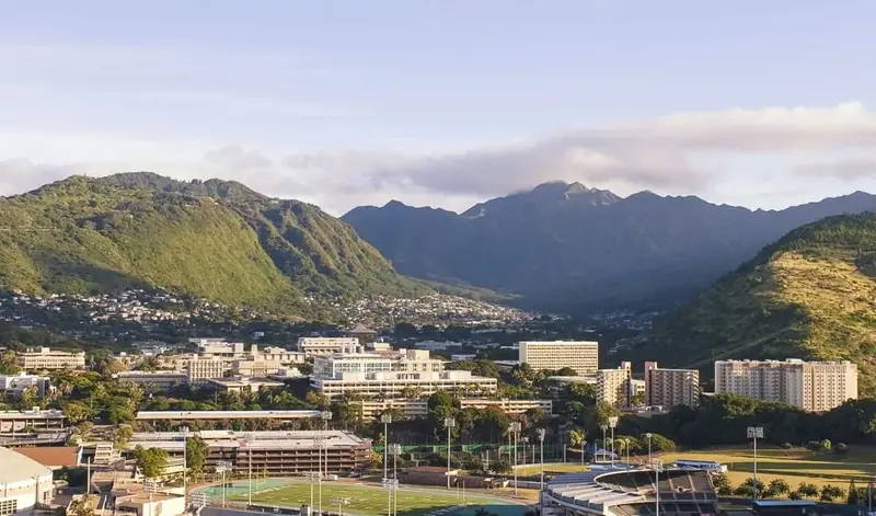 View of the University of Hawaii at Mānoa campus with surrounding green mountains